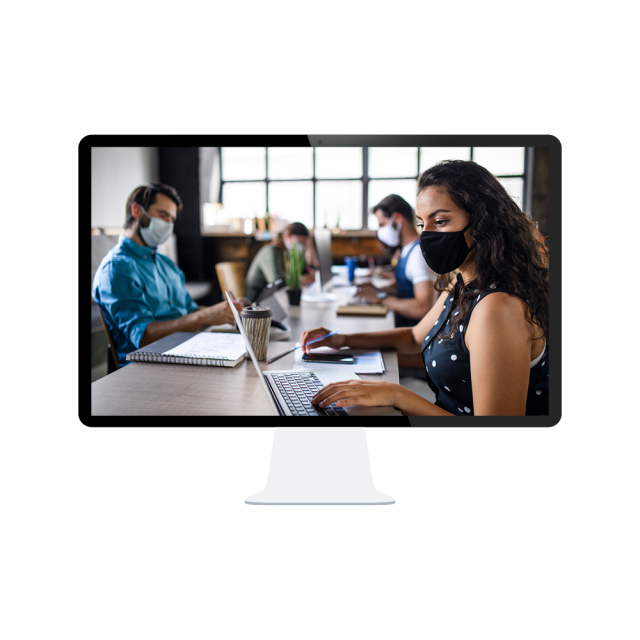 A computer screen shows office workers socially distanced with masks on.